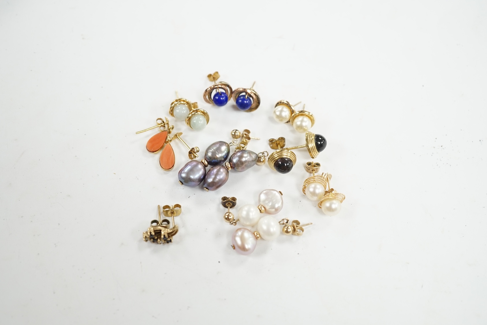 Seven assorted modern pairs of 9ct and gem set earrings and two similar yellow metal pairs. Condition - fair